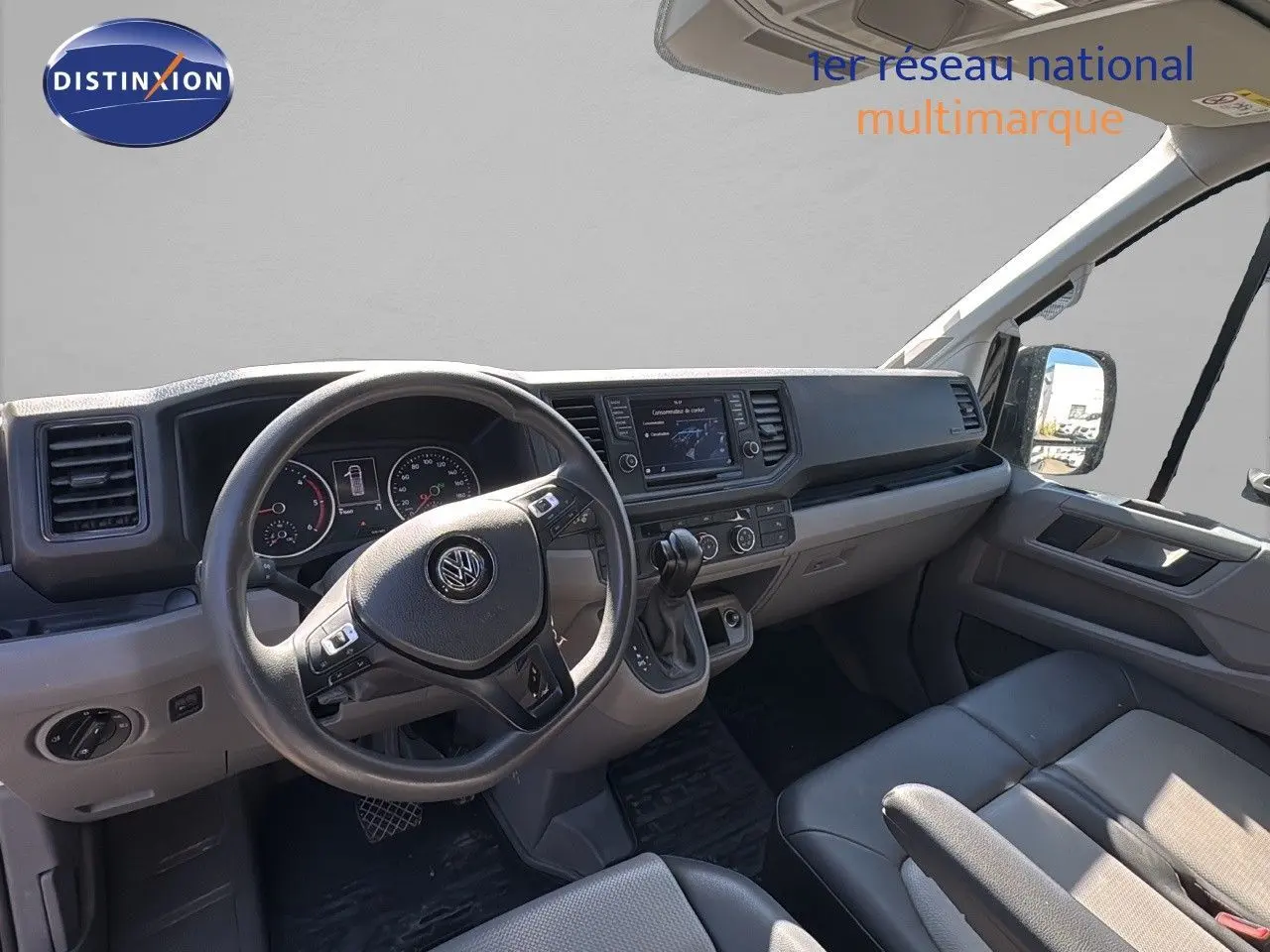 Vue intérieure côté conducteur du Volkswagen Crafter Fourgon 2020 avec tableau de bord moderne et sièges gris.