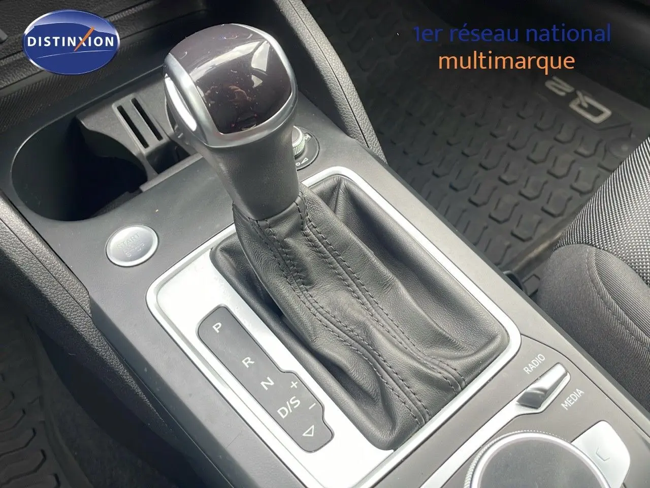 Le levier de vitesses automatique noir en cuir de l'Audi Q2 35 TFSI S-Line, vue rapprochée de la console centrale.