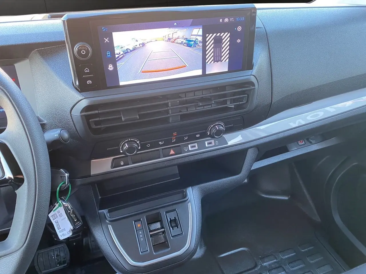 Vue intérieure du tableau de bord du Peugeot Expert cabine approfondie 2025, avec écran tactile et commandes centrales.