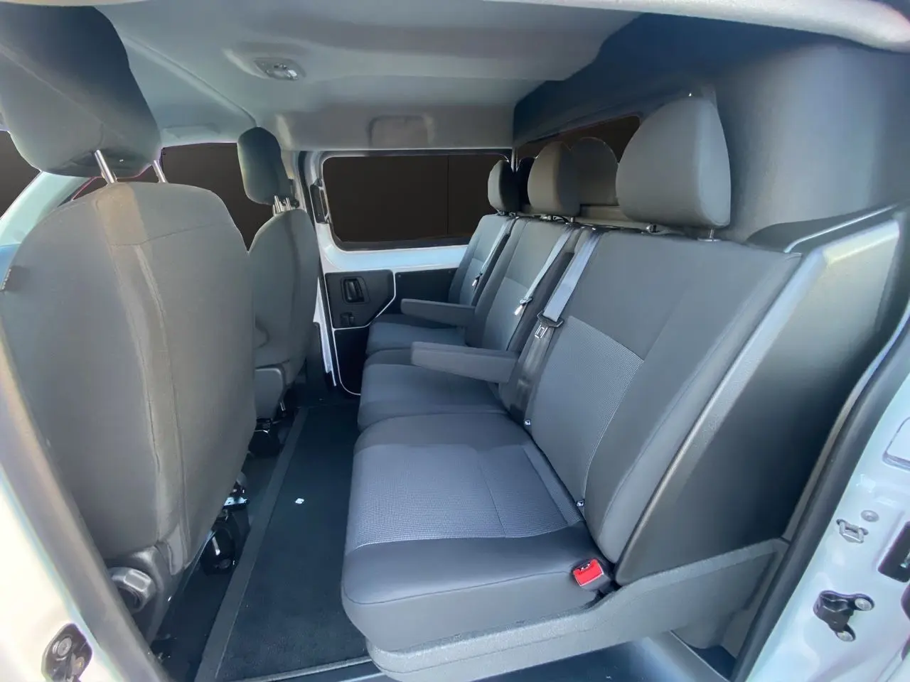Vue intérieure côté droit du Peugeot Expert Cabine Approfondie 2025, sièges tissu bi-ton gris et noir sur 3 places arrière.