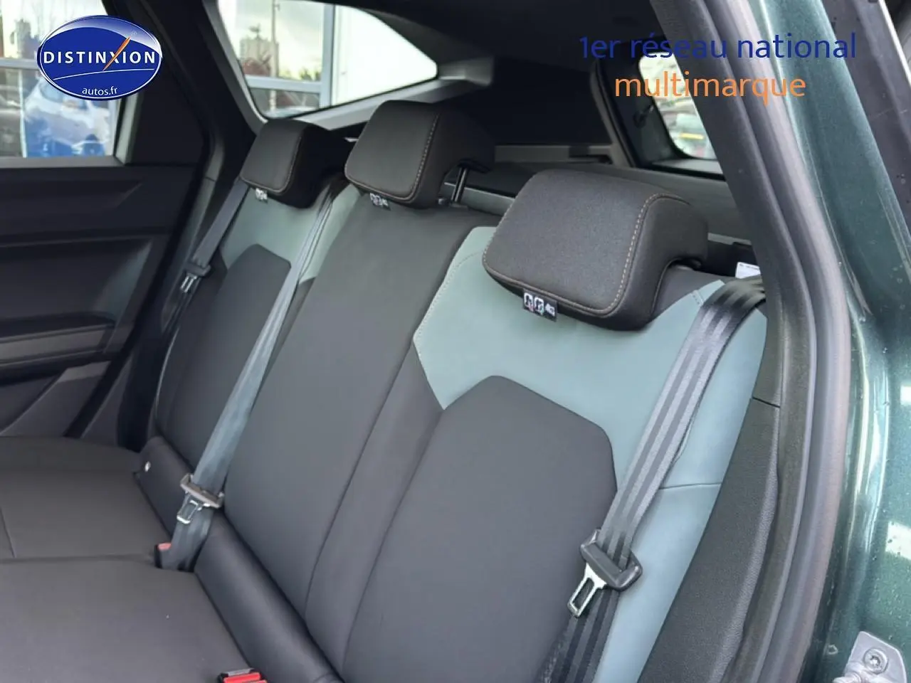 Vue intérieure sur la banquette arrière du Dacia Bigster vert cèdre, avec ceintures de sécurité et appuie-têtes visibles.