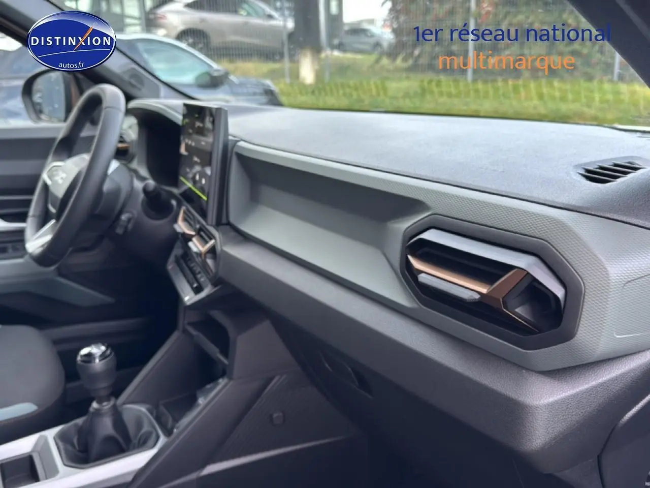 Intérieur du Dacia Bigster 2025 vue côté passager, tableau de bord gris avec aérateurs hexagonaux cuivrés.