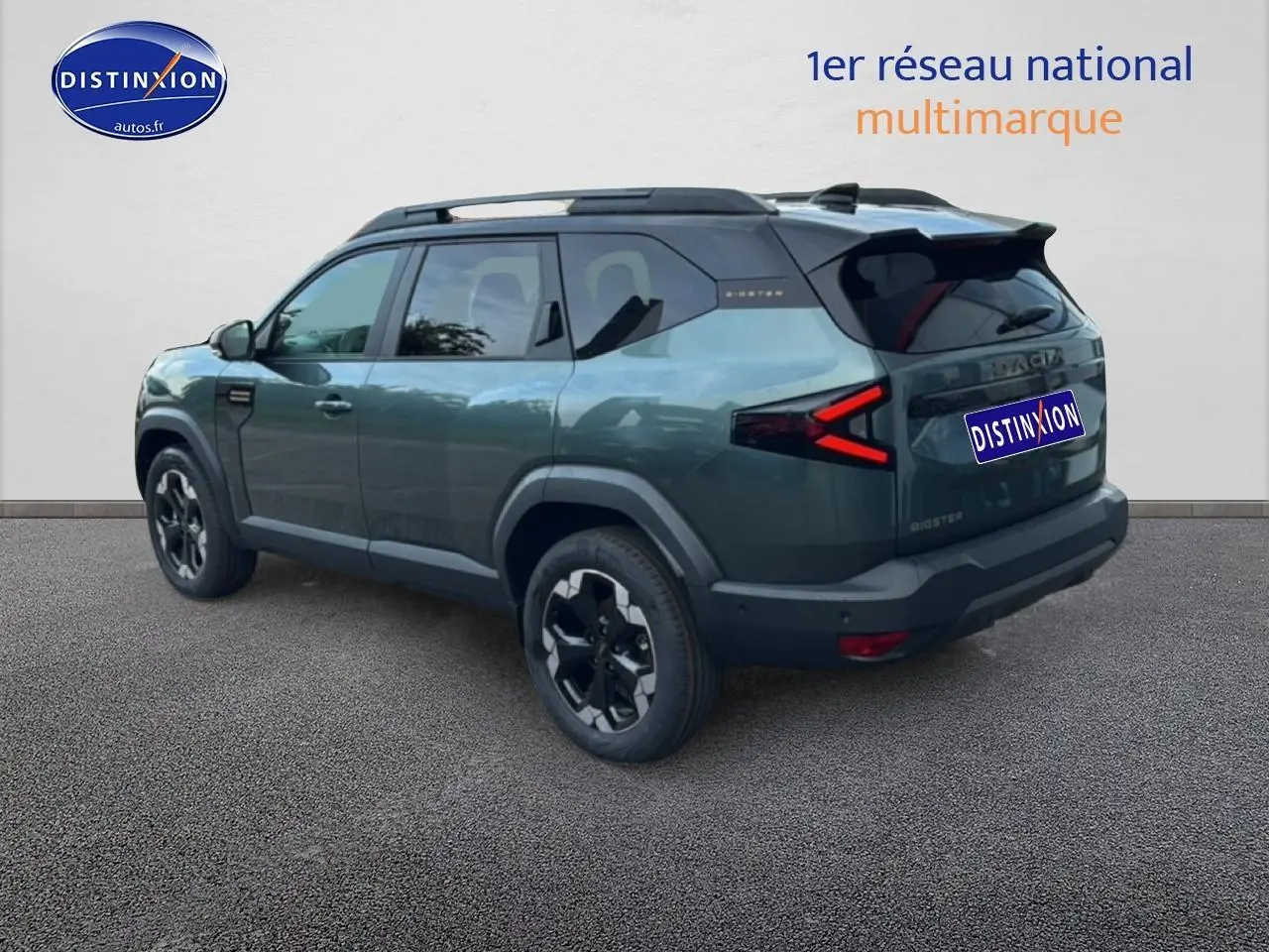 Vue 3/4 arrière droite du SUV Dacia Bigster vert cèdre avec barres de toit noires et feux arrière LED en forme de flèche.