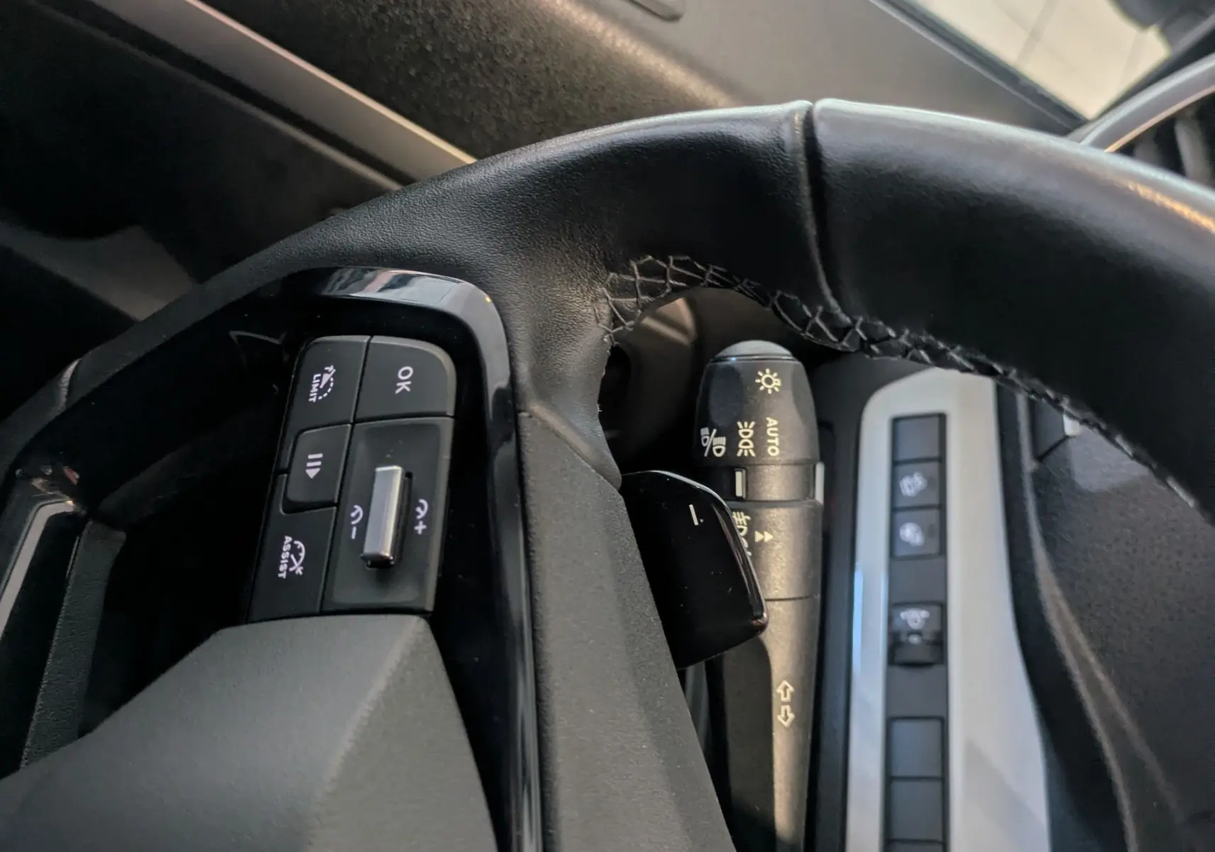 Gros plan sur le volant côté gauche de l’Opel Vivaro Fourgon blanc, avec commandes au volant et régulateur de vitesse.