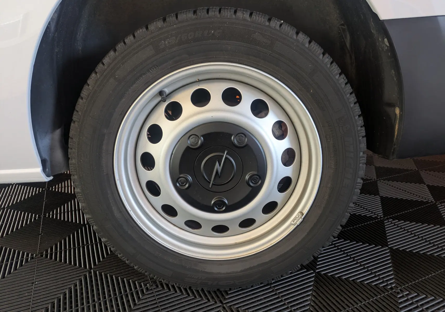 Gros plan sur la roue arrière droite avec jante tôle 17 pouces grise du fourgon blanc Opel Vivaro XL 2024.