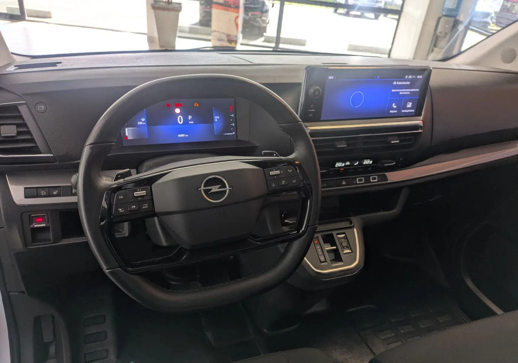 Vue intérieure du poste de conduite de l'Opel Vivaro Fourgon XL 2024, tableau de bord moderne avec écran digital et volant multifonction noir.