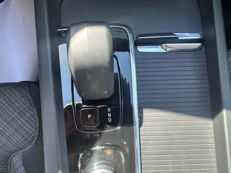 Gros plan sur la console centrale de la Volvo S60 gris Platinium, montrant le levier de vitesses automatique et un rangement coulissant.