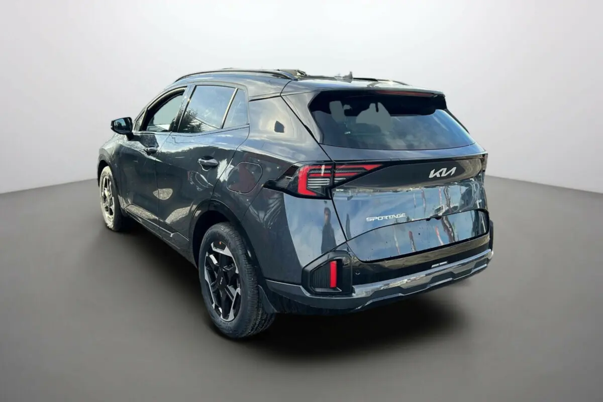Vue 3/4 arrière gauche d’un KIA Sportage 2026 gris eclipse avec toit noir et feux arrière LED distinctifs.