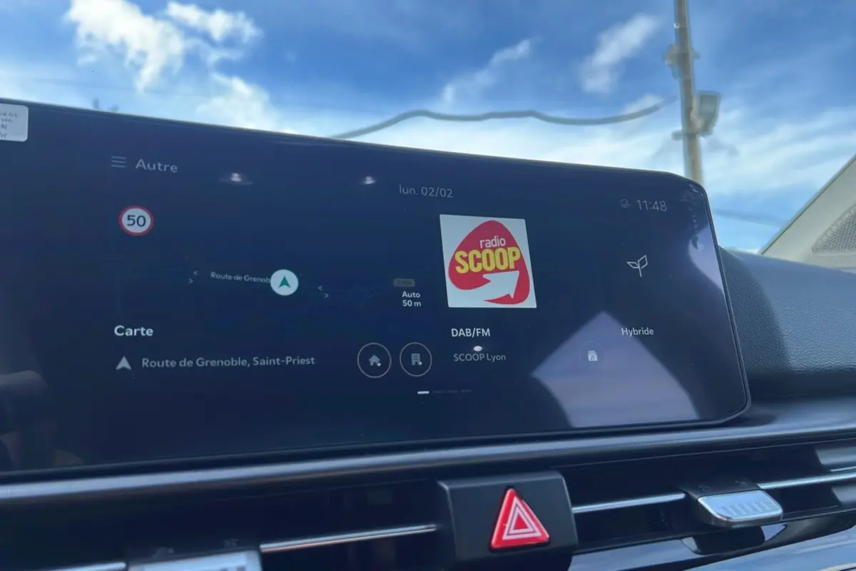 Écran tactile central affichant la navigation et la radio dans un Kia Sportage 1.6 T-GDI HEV 239 GT toit panoramique.