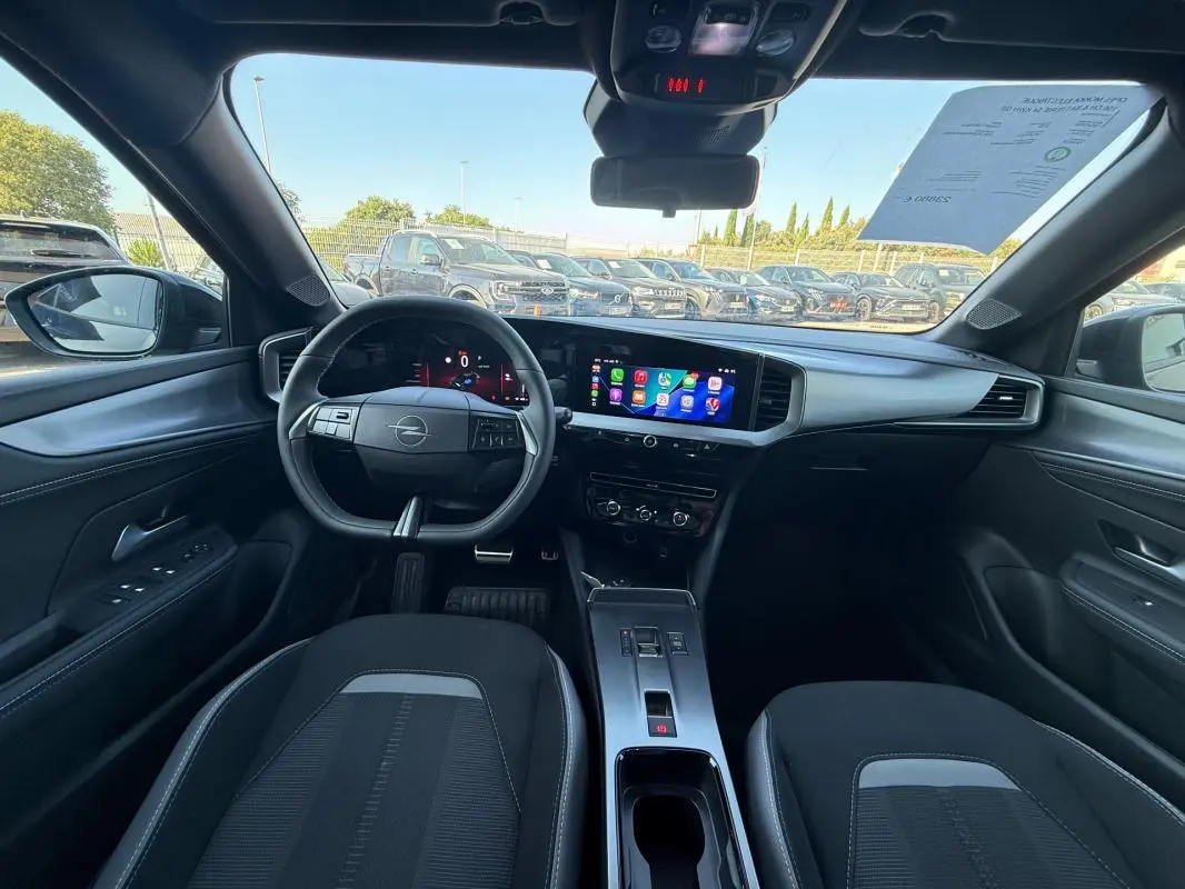 Vue intérieure avant de l’Opel Mokka électrique 2025, tableau de bord moderne avec écran tactile et volant noir.