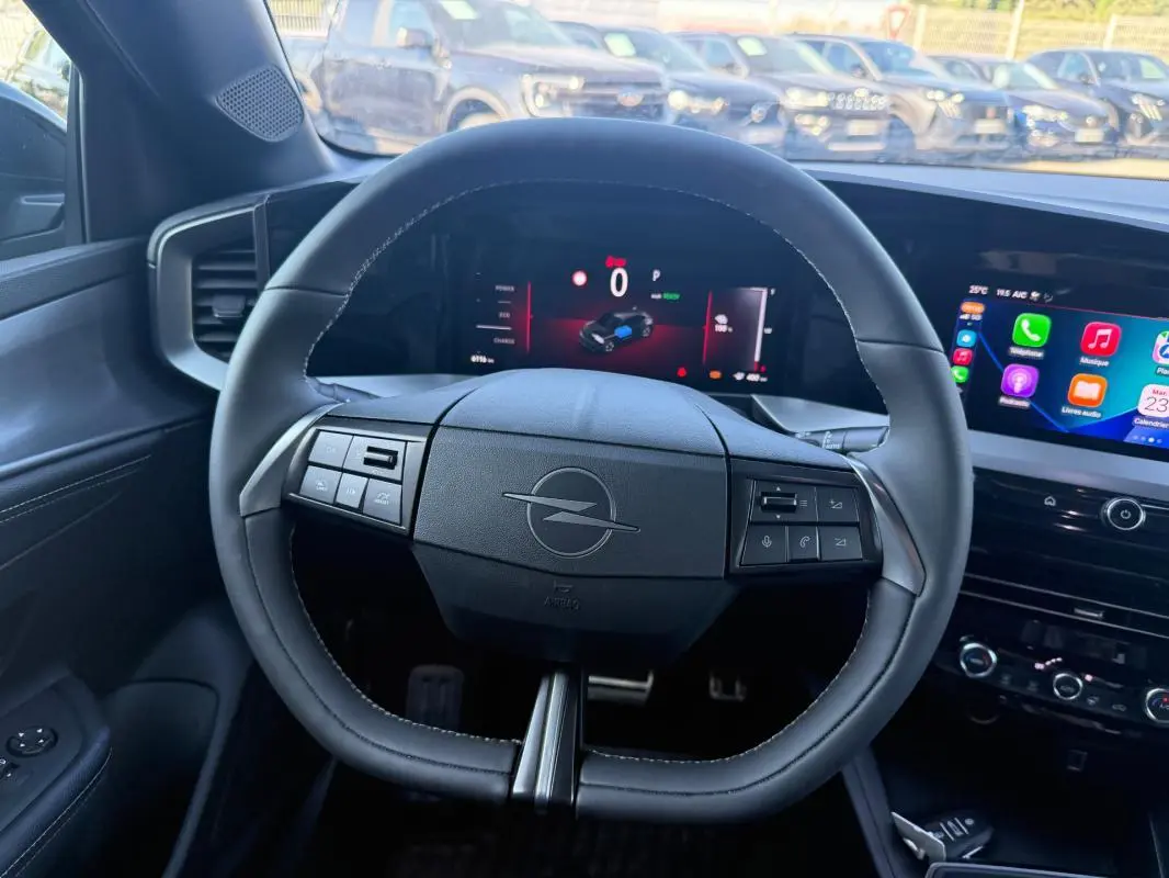 Vue intérieure centrée sur le volant noir de l'Opel Mokka électrique 2025 avec tableau de bord numérique et écran tactile.
