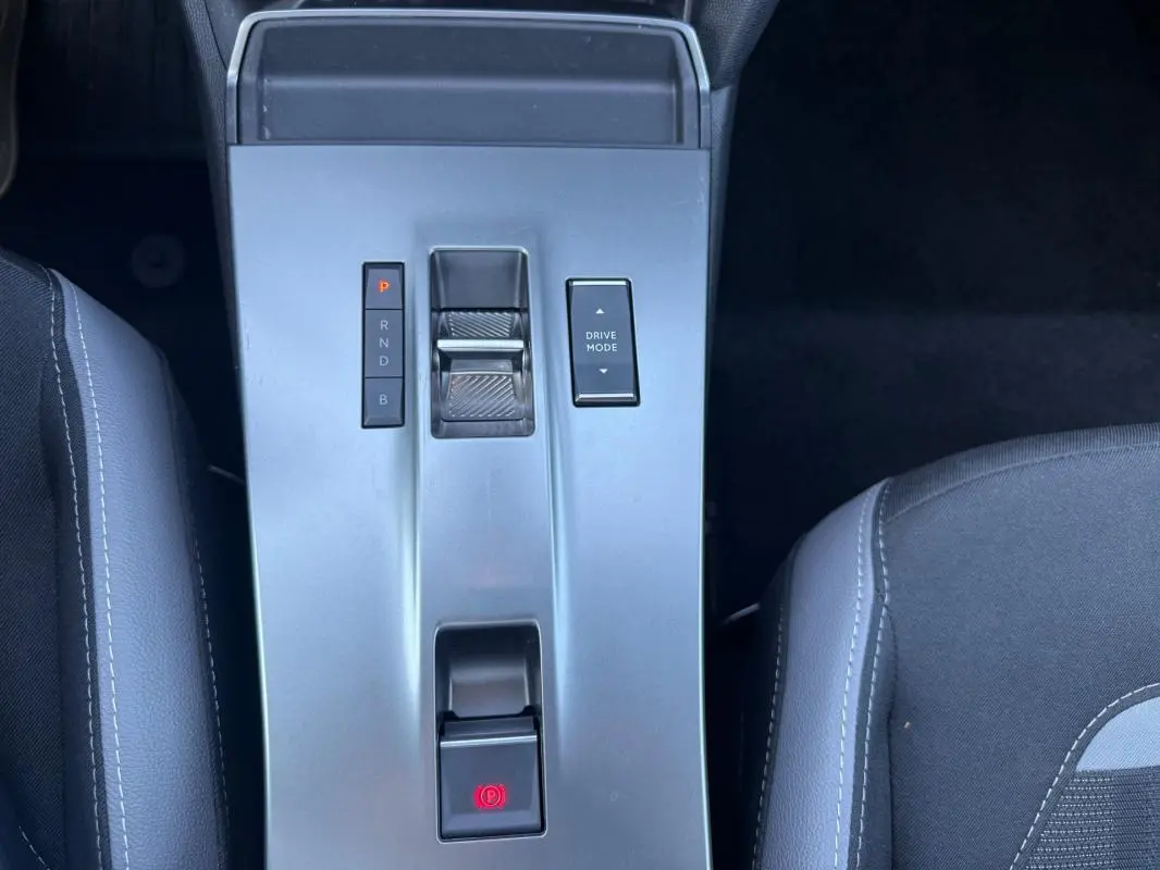 Vue plongeante sur la console centrale grise de l’Opel Mokka électrique 2025 avec commandes de boîte auto et mode de conduite.