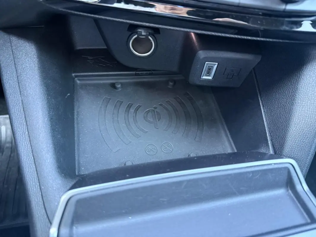 Gros plan sur le compartiment de recharge sans fil et port USB dans l’habitacle noir de l’Opel Mokka électrique 2025.