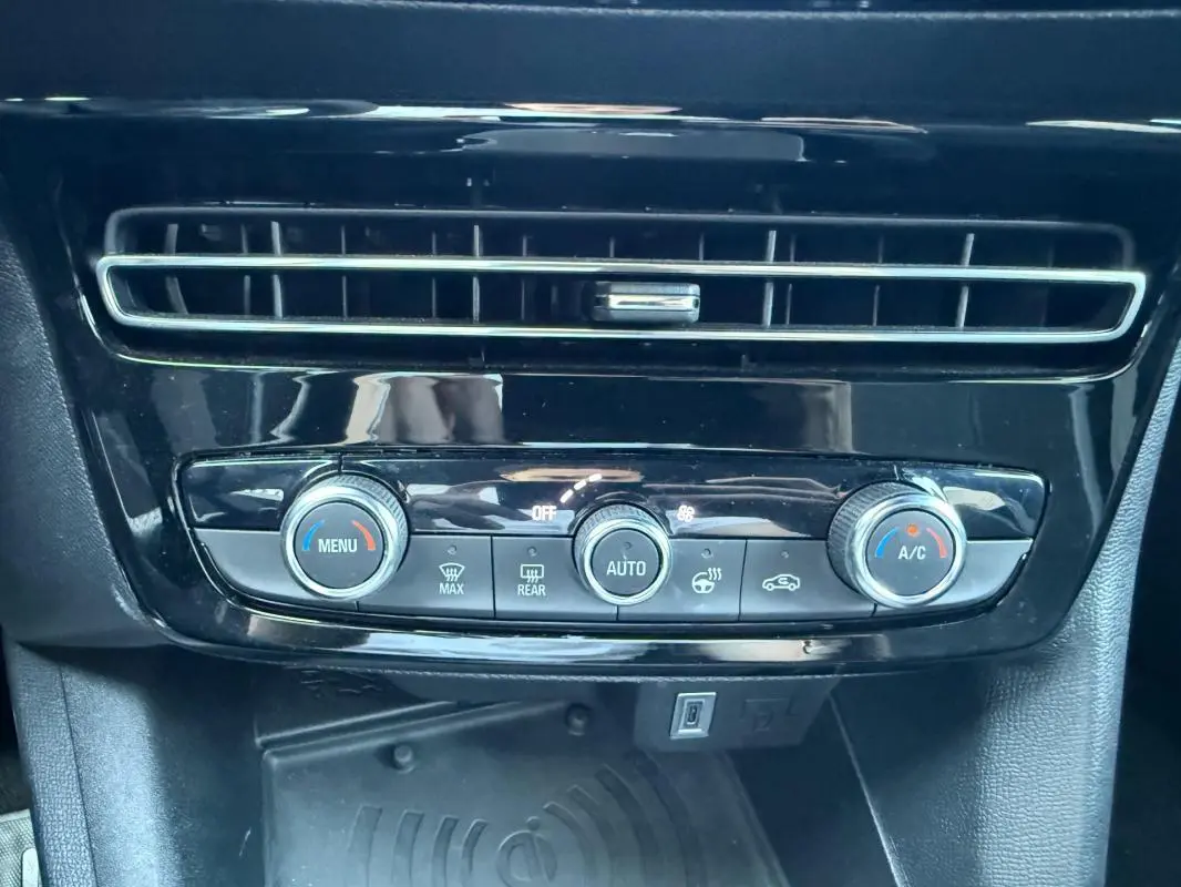 Détail de la console centrale noire de l’Opel Mokka électrique 2025 avec commandes de climatisation automatique et aérateurs.