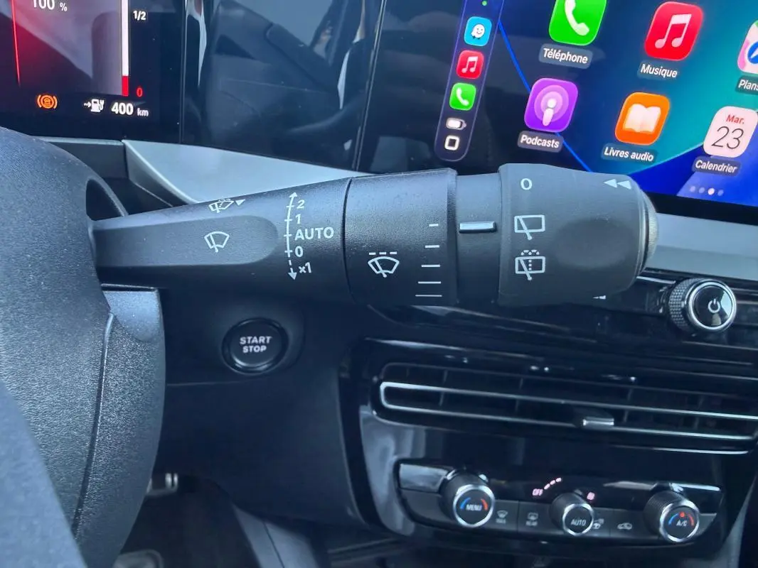 Gros plan sur la commande d’essuie-glace à gauche du volant dans l’habitacle noir de l’Opel Mokka électrique 2025.