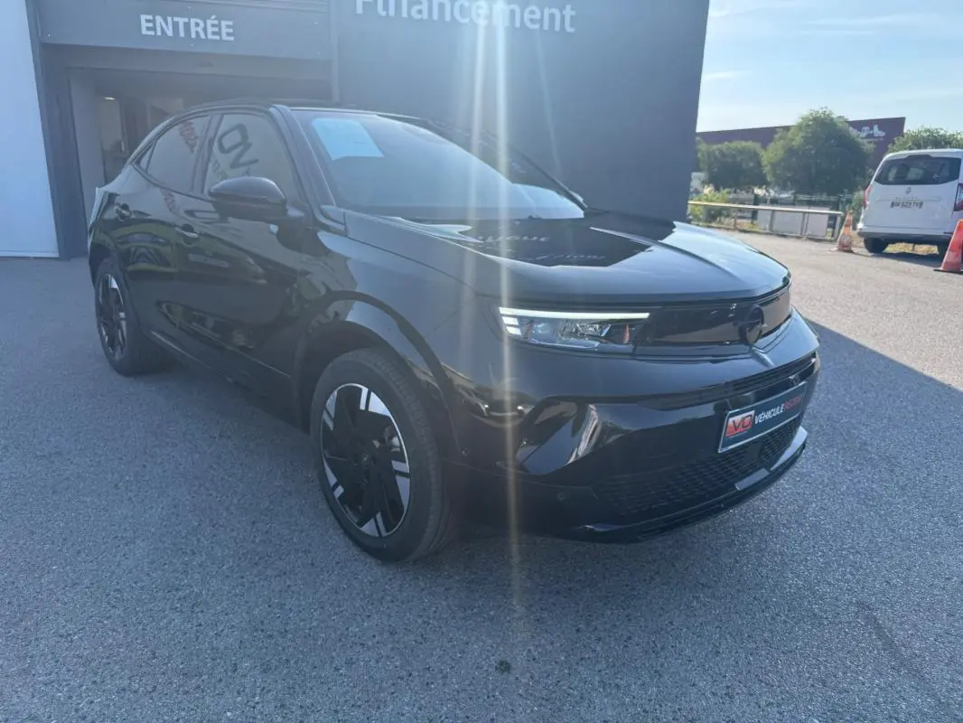 Opel Mokka électrique noir vue 3/4 avant droit, jantes alliage 17 pouces et vitres surteintées visibles.