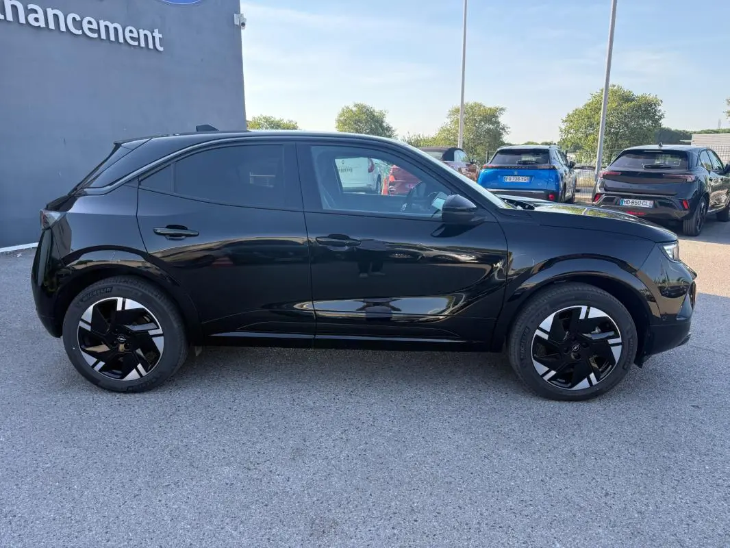 Profil côté gauche de l'Opel Mokka électrique noir 2025 avec jantes alliage 17 pouces et vitres surteintées.