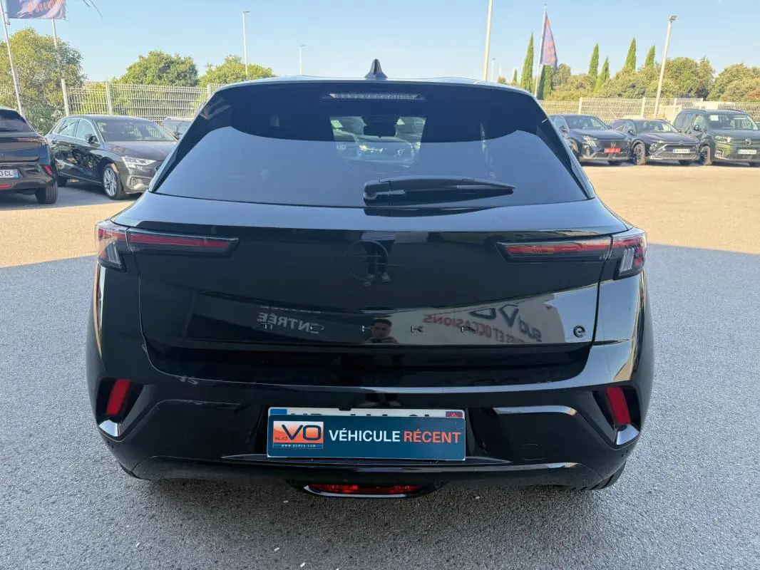 Vue arrière d’un Opel Mokka électrique noir 2025 avec feux arrière fins et vitres surteintées.