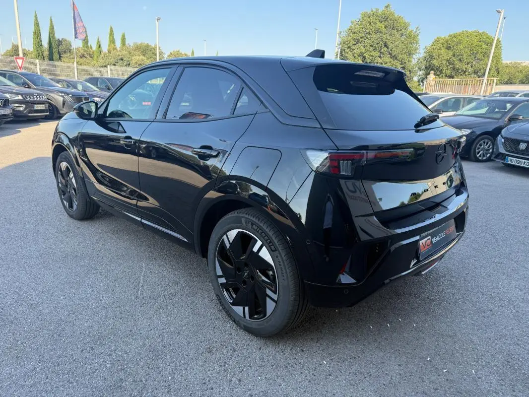 Opel Mokka électrique noir vu en 3/4 arrière droit, avec jantes alliage 17 pouces et vitres surteintées.