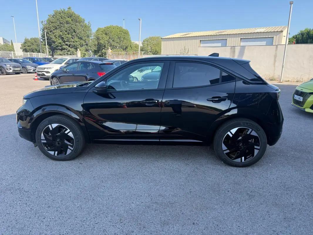 Opel Mokka électrique noir vue de profil côté gauche, avec jantes alliage 17 pouces et vitres surteintées.