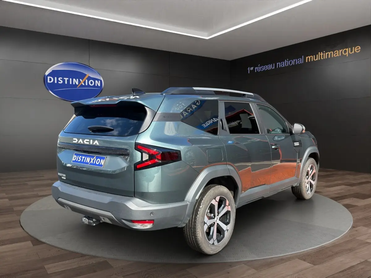 Vue 3/4 arrière droite du Dacia Bigster vert avec attelage RDSO et jantes alliage en showroom.