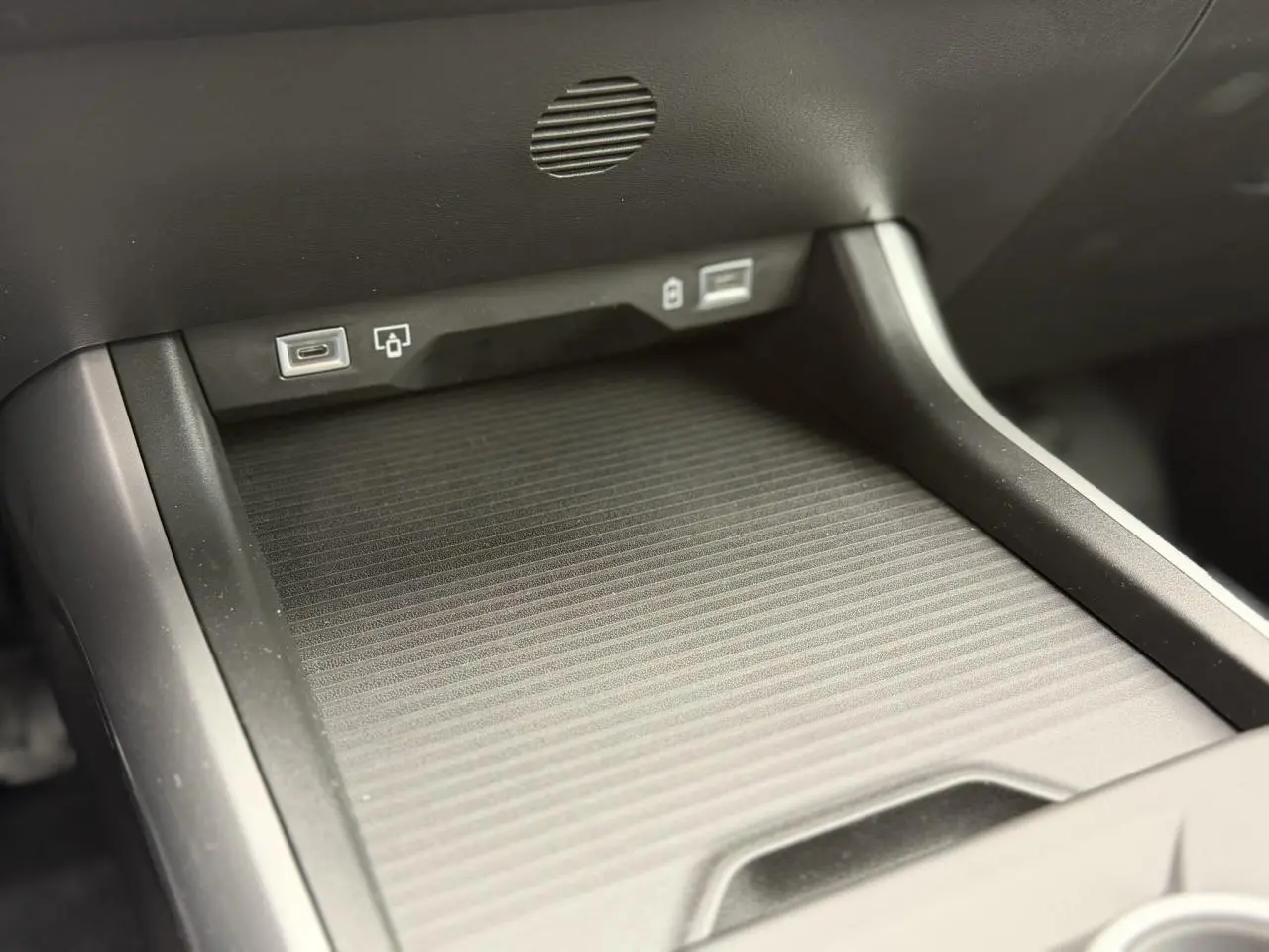 Gros plan sur la console centrale du Jeep Compass 2026, montrant le chargeur sans fil et ports USB.