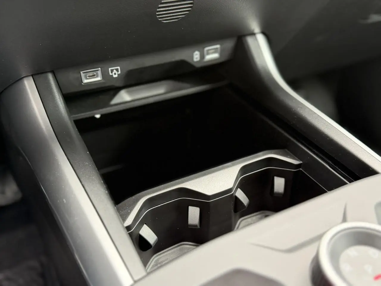 Gros plan sur la console centrale noire du Jeep Compass 2026, montrant les porte-gobelets et ports USB.
