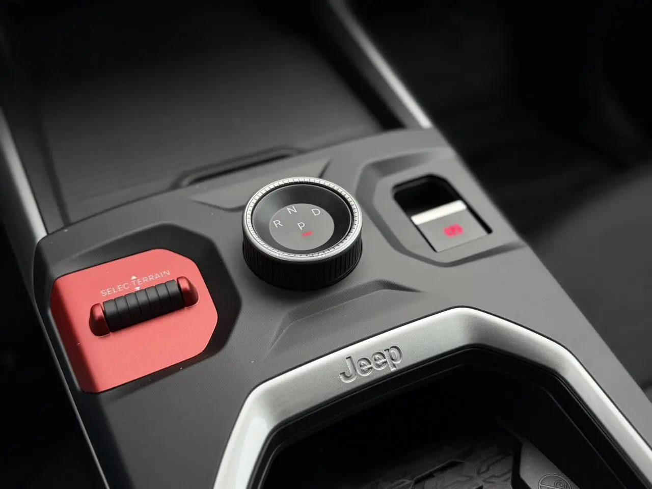 Gros plan sur la console centrale du Jeep Compass 2026, avec sélecteur de vitesse rotatif et bouton rouge Selec-Terrain.
