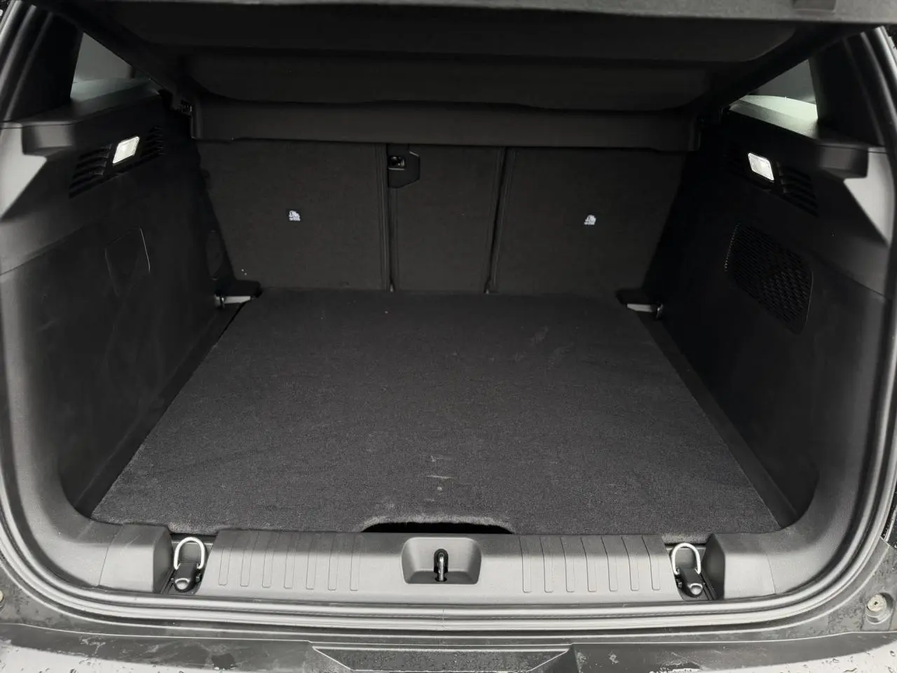Coffre ouvert vu de l'arrière du Jeep Compass noir Vulcano, espace de chargement propre et vide.