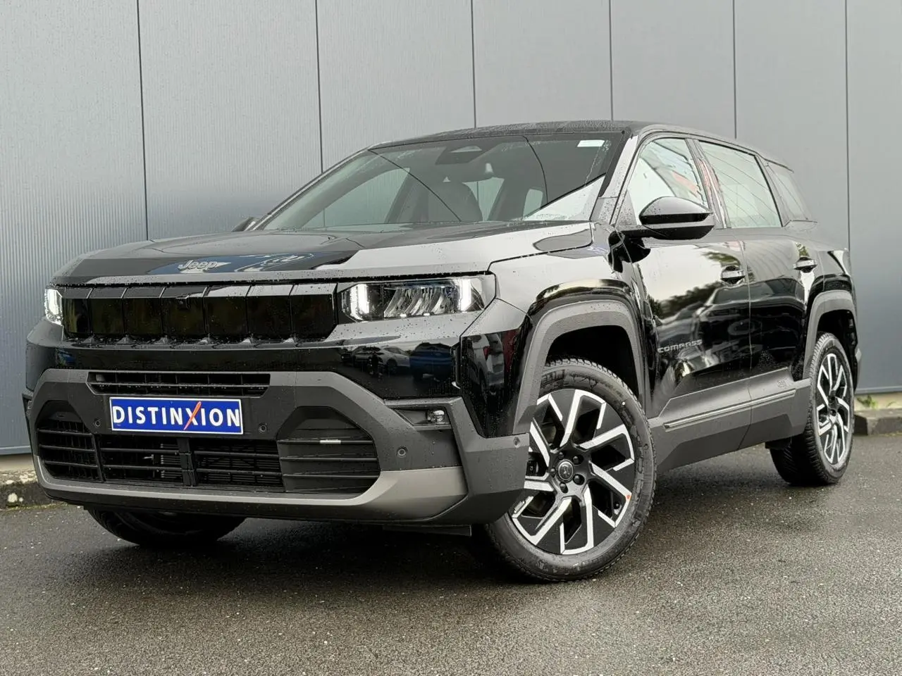 Jeep Compass noir Vulcano en 3/4 avant droit, avec jantes alliage 19 pouces et calandre noire distinctive.