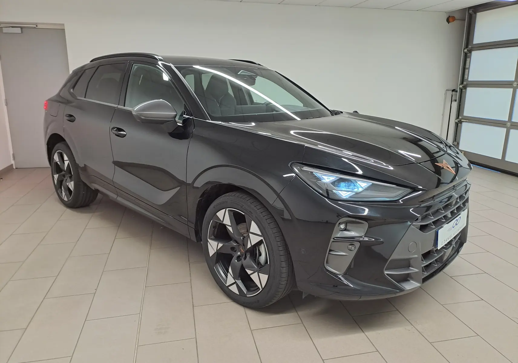 Vue 3/4 avant du CUPRA TERRAMAR noir minuit avec jantes 20'' Gravity usinées dans un showroom intérieur.
