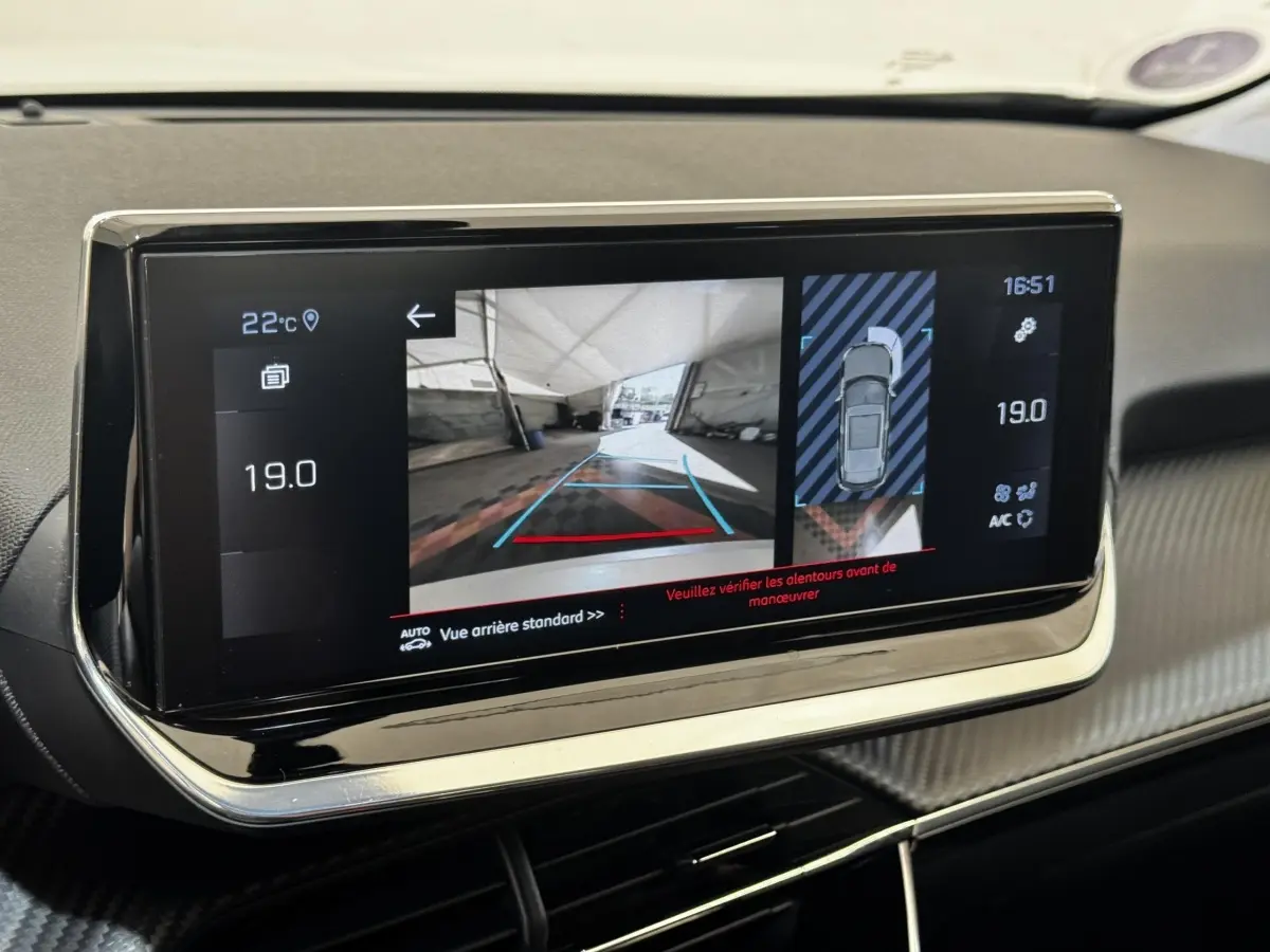 Écran tactile intérieur du Peugeot 2008 blanc, affichant la caméra de recul et l'aide au stationnement arrière.