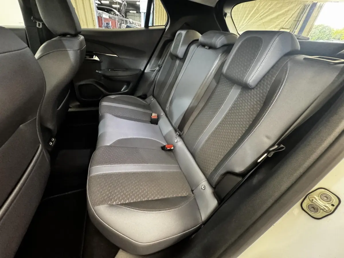 Vue intérieure côté droit des sièges arrière gris foncé de la Peugeot 2008 blanc 2021 avec ceinture et appuie-têtes.