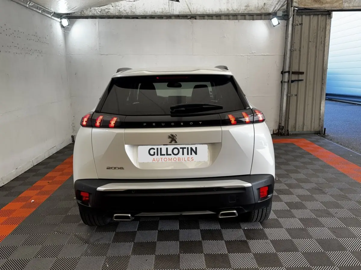 Vue arrière d’un Peugeot 2008 blanc avec feux LED caractéristiques et double sortie d’échappement rectangulaire.