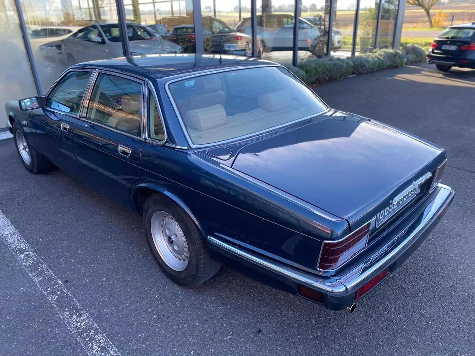 Jaguar XJ6 3.6 Sovereign bleu vue 3/4 arrière droit, carrosserie brillante et jantes classiques en alliage.