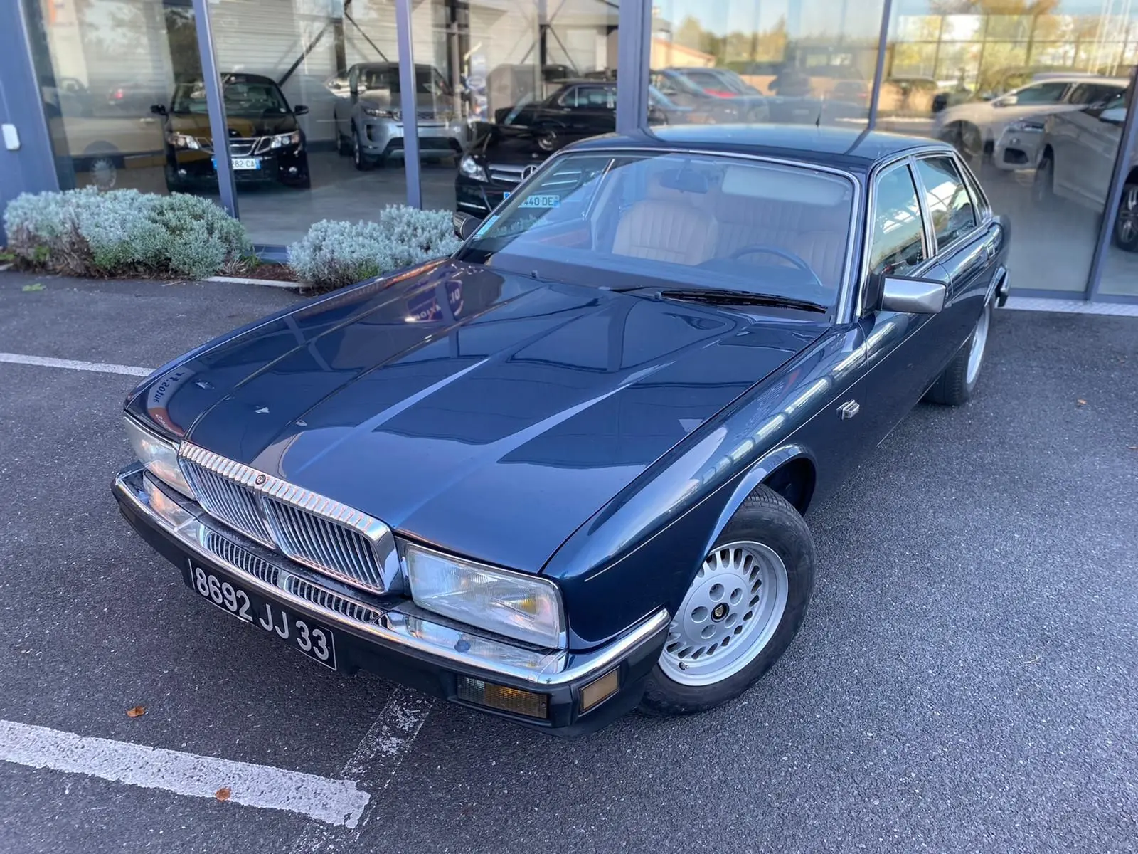 Jaguar XJ6 3.6 Sovereign bleu vue 3/4 avant droit, avec calandre chromée et jantes alliage classiques.