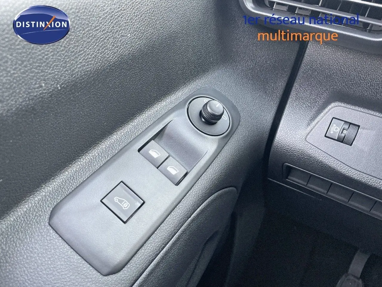 Détail des commandes de réglage des rétroviseurs et vitres côté conducteur du Peugeot Partner 2025, intérieur noir.