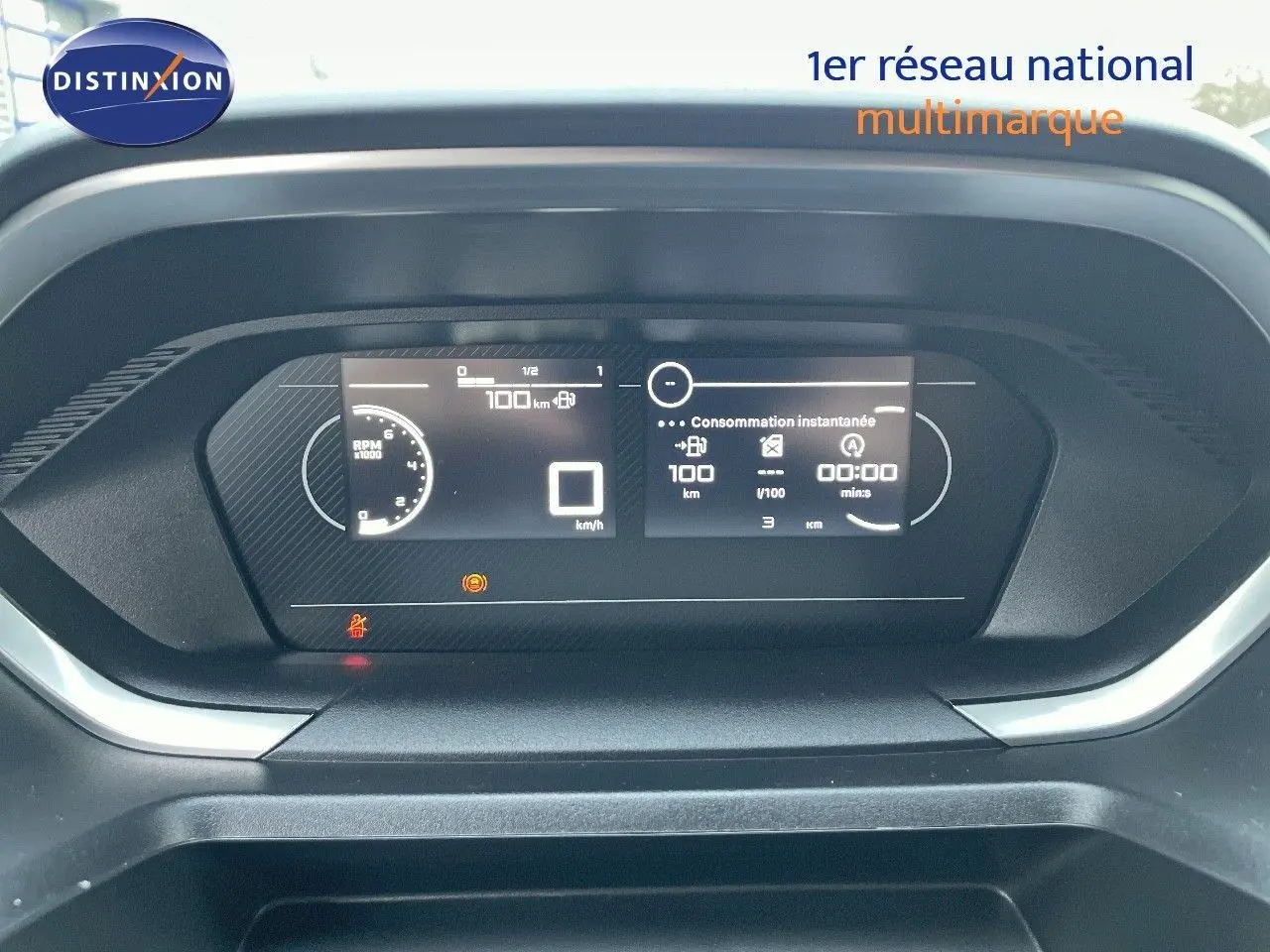Tableau de bord numérique du Peugeot Partner 2025, affichage de la consommation instantanée et compteur de vitesse à 0 km/h.
