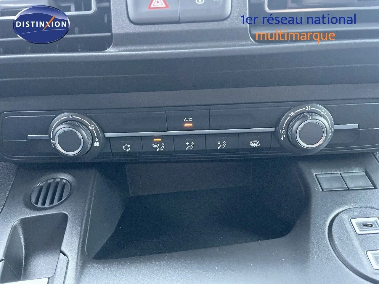 Vue rapprochée du tableau de bord noir du Peugeot Partner 2025, montrant les commandes de climatisation et ventilation.