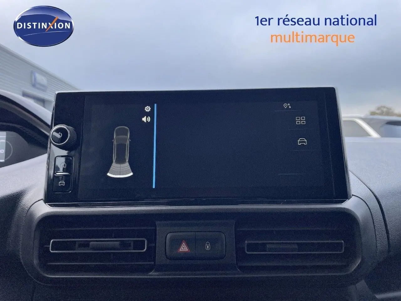 Écran tactile central du tableau de bord du Peugeot Partner 2025, affichant l'aide au stationnement.