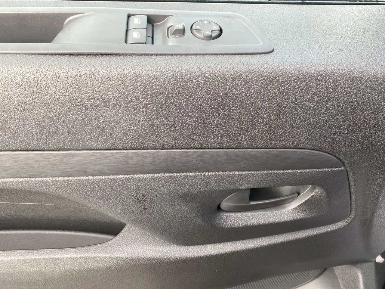 Détail de la porte intérieure côté conducteur du Peugeot Expert gris titane avec commandes électriques des vitres.