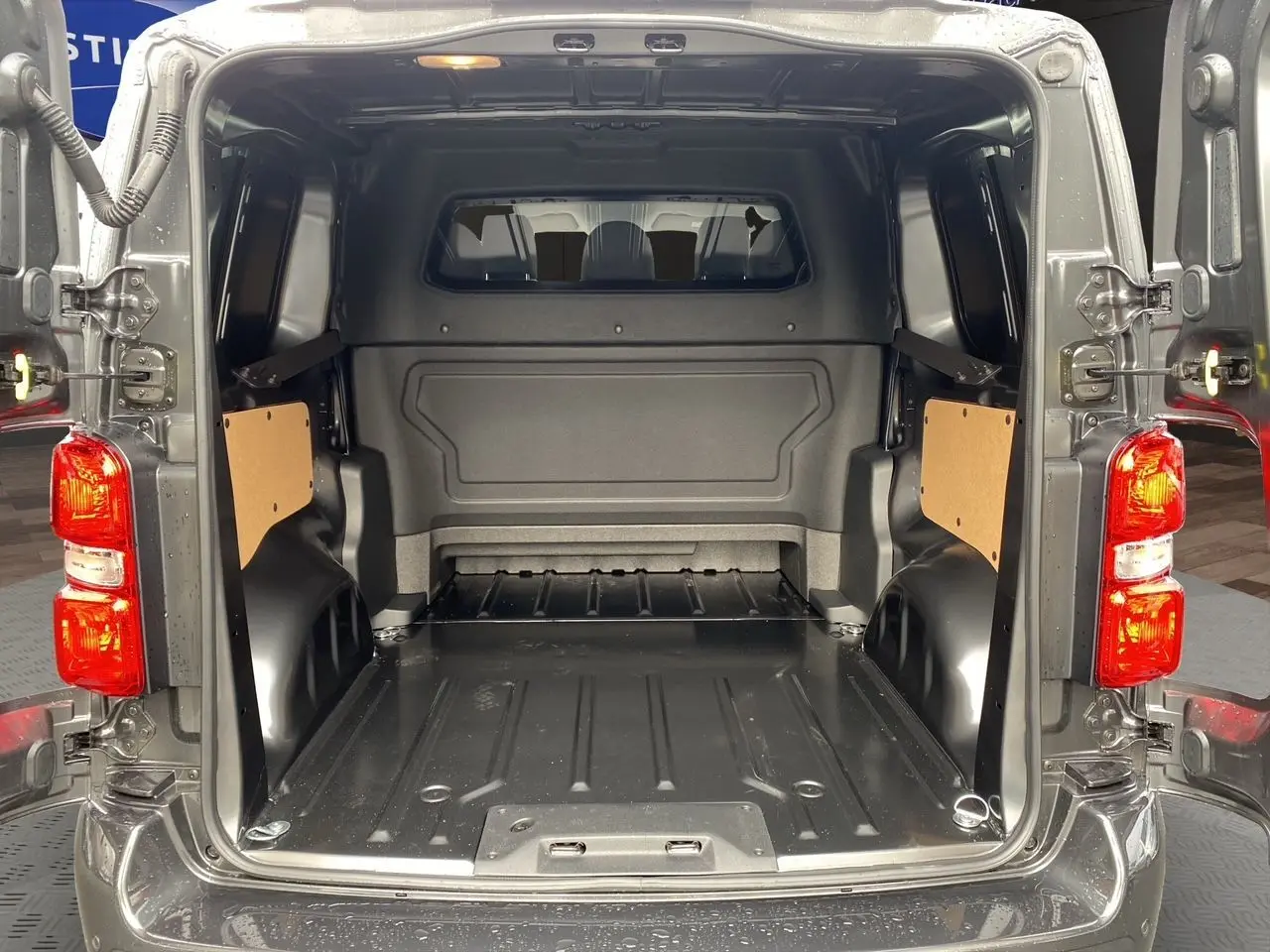 Vue arrière du Peugeot Expert Cabine Approfondie gris titane, portes ouvertes montrant l’espace de chargement vide.