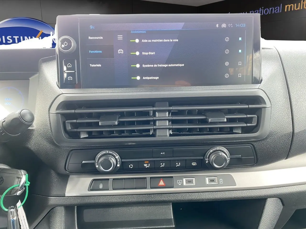 Vue rapprochée de la console centrale du Peugeot Expert gris titane, avec écran tactile et commandes climatisation.