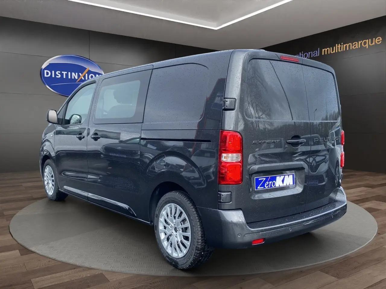 Vue 3/4 arrière droite d’un Peugeot Expert Cabine Approfondie gris titane avec jantes argentées et vitres latérales teintées.