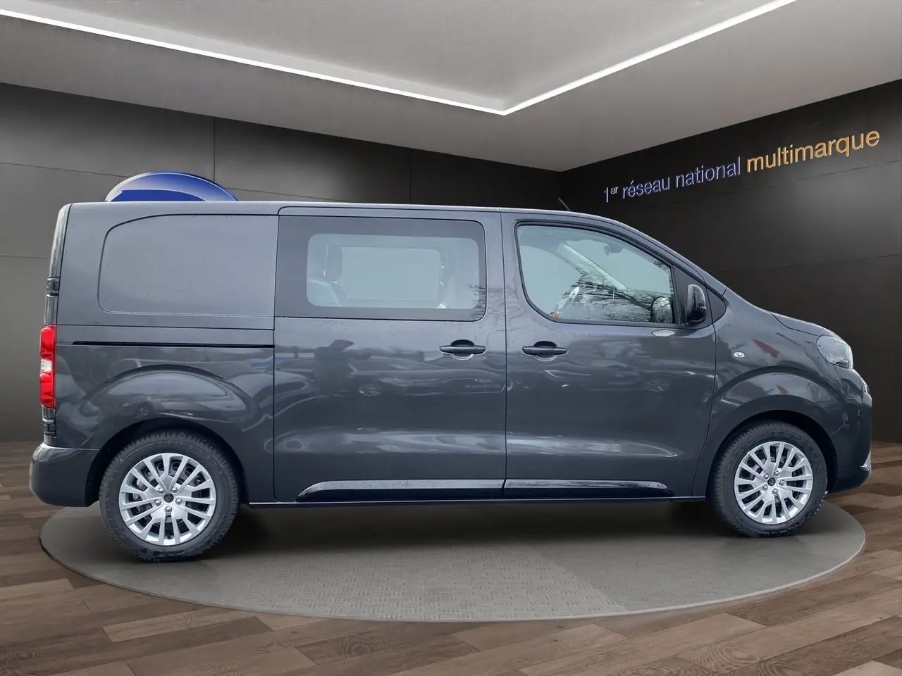 Vue de profil côté gauche d'un Peugeot Expert Cabine Approfondie gris titane avec jantes alliage et vitres teintées.