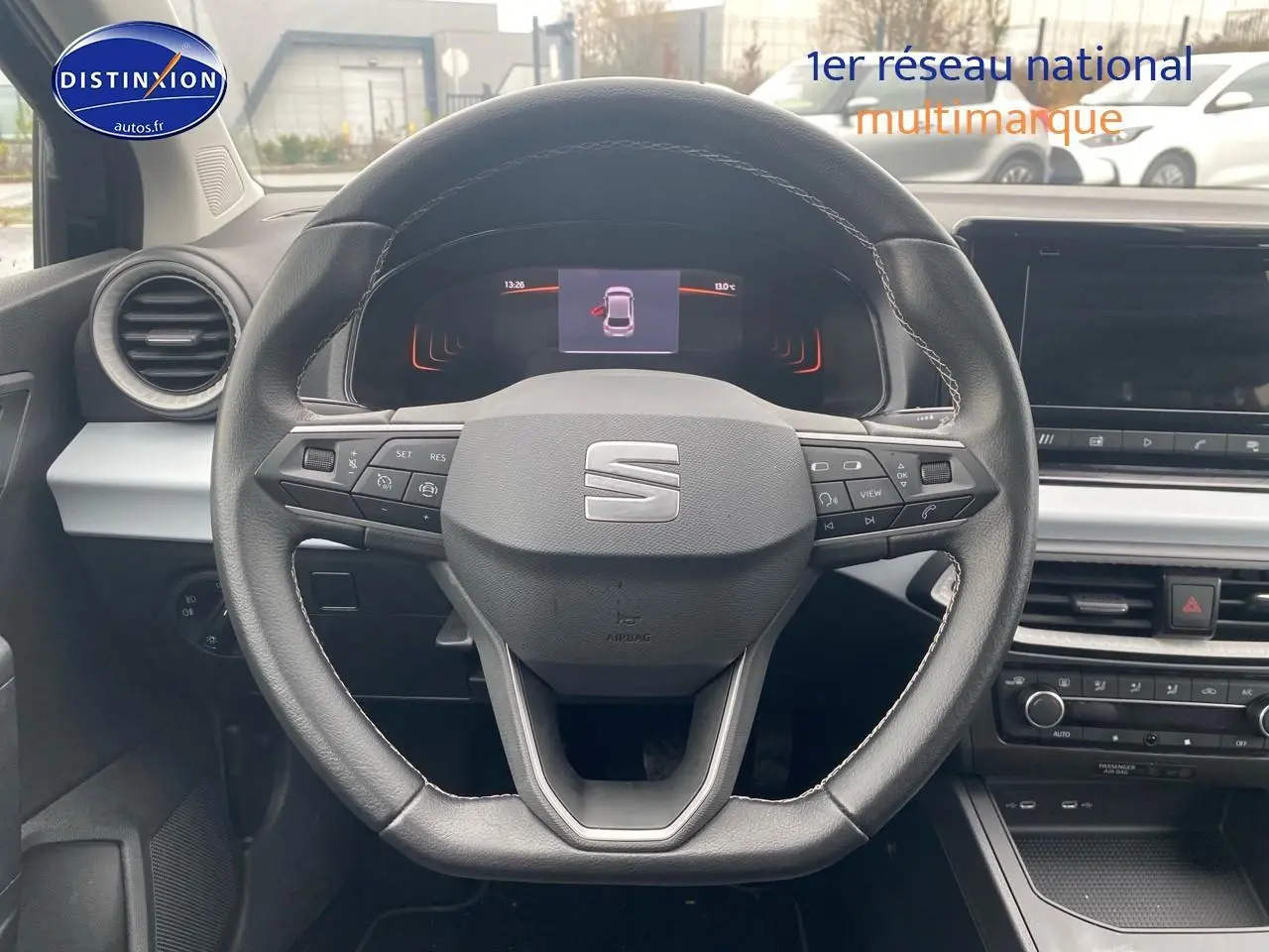Vue centrée sur le volant cuir méplat de la SEAT Ibiza noir minuit, avec tableau de bord digital et écran tactile.