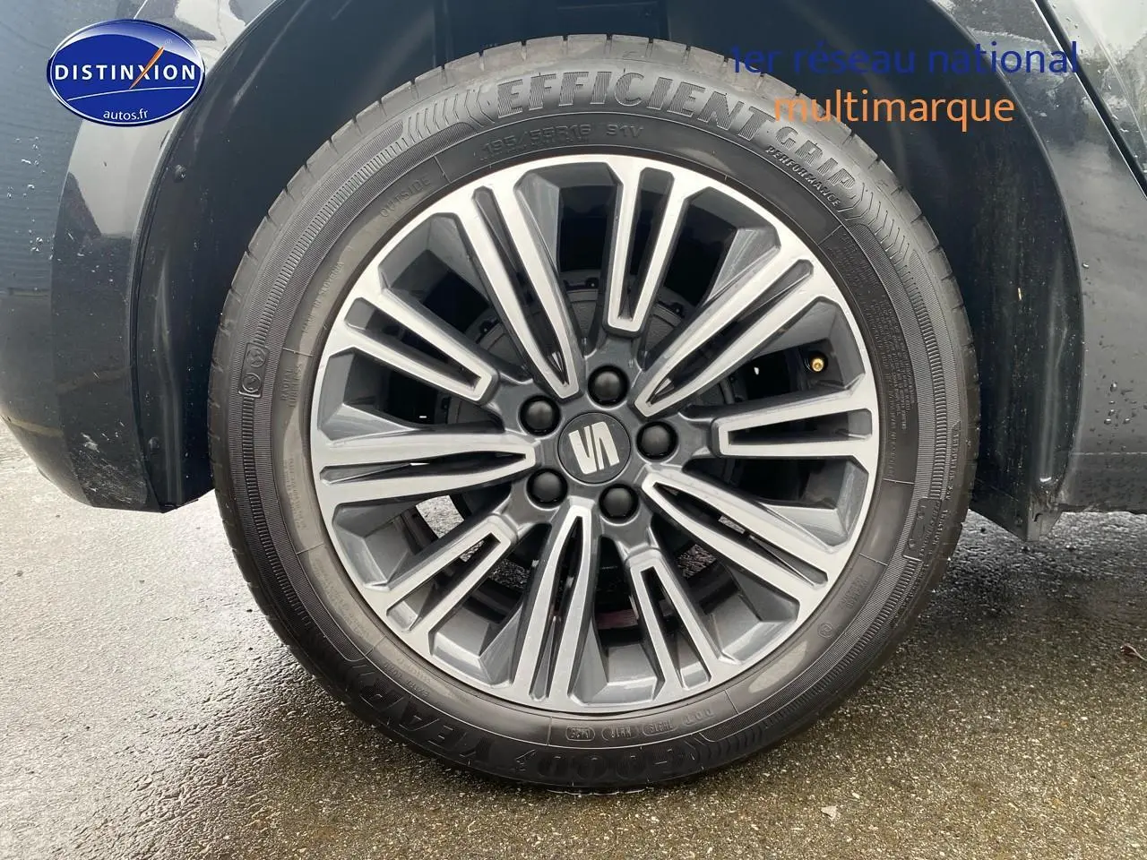 Gros plan sur la jante alliage 16 pouces de la SEAT Ibiza noir minuit, roue avant droite visible sur sol humide.