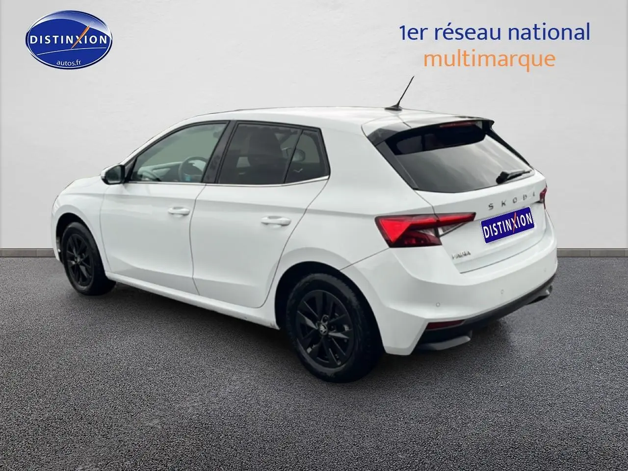 Vue 3/4 arrière droite d'une Skoda Fabia blanche avec jantes noires et feux arrière LED visibles.