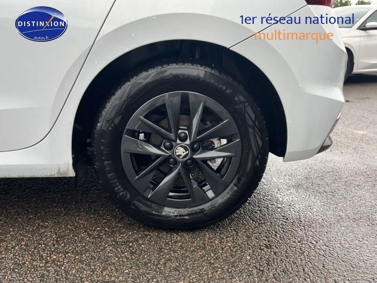 Gros plan sur la roue arrière droite noire avec jante alu d'une Skoda Fabia blanche essence 2025.