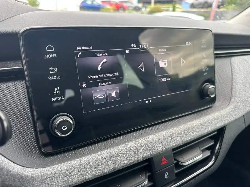 Écran tactile central de la Skoda Scala 2025, affichant les options média et téléphone, avec tableau de bord gris.